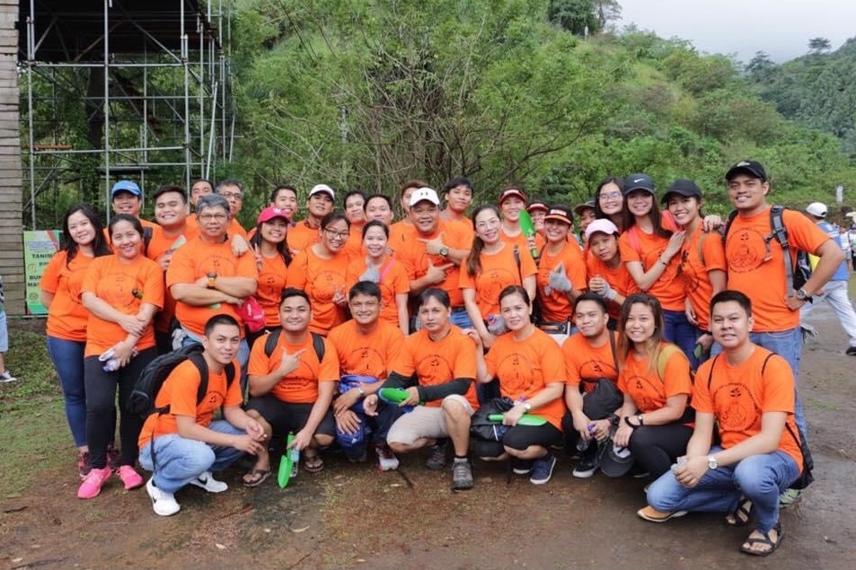 employees taking group photo in forest